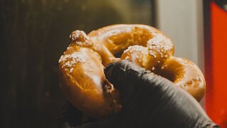Brezel in Hand gehalten. @ 
