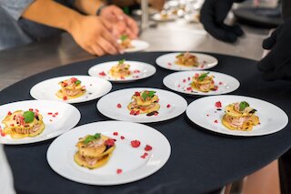 Mehrere weiße Teller mit garnierten Canapés beim Catering @ 