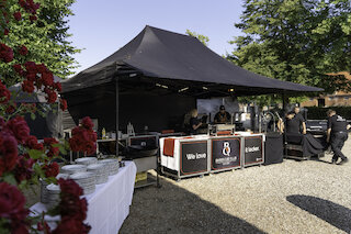 Mobile Barbecue-Club-Catering-Station unter schwarzem Pavillon mit Geschirrtisch im Vordergrund @ 