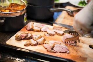 Frisch gegrilltes Fleisch wird beim BBQ-Catering in Köln portioniert @ 