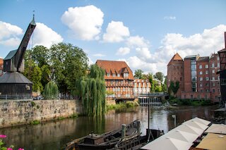 Alter Kran und Backsteinbauten an der Ilmenau mit Booten in Lüneburg @ 